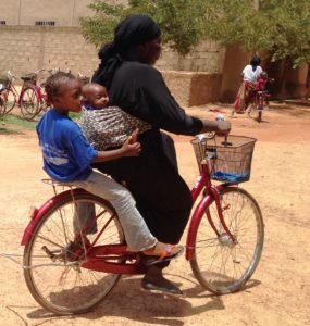 FAR's bike beneficiary carrying her daughter to school