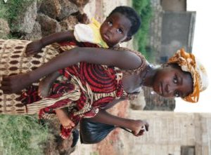 Coming back from the market after buying vegetables to prepare dinner, carriny my little cousin on my back