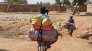 Bikes as the only possible mode of transportation. Two Zongo women carry their small businesses’ goods